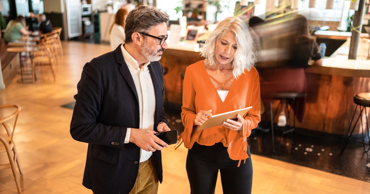 Man and woman talking in office, using Vertafore Email Agent