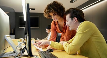 man and woman looking at a computer