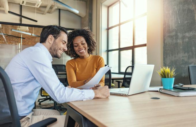 Two people working together on a laptop