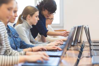 a row of people using computers at a table