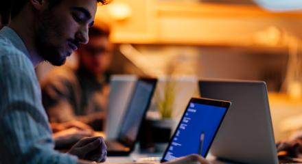 Man working on laptop late night in office