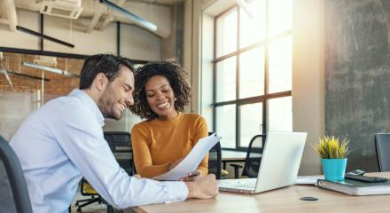 Two people working together on a laptop