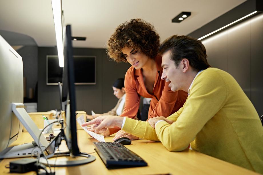 man and woman looking at a computer